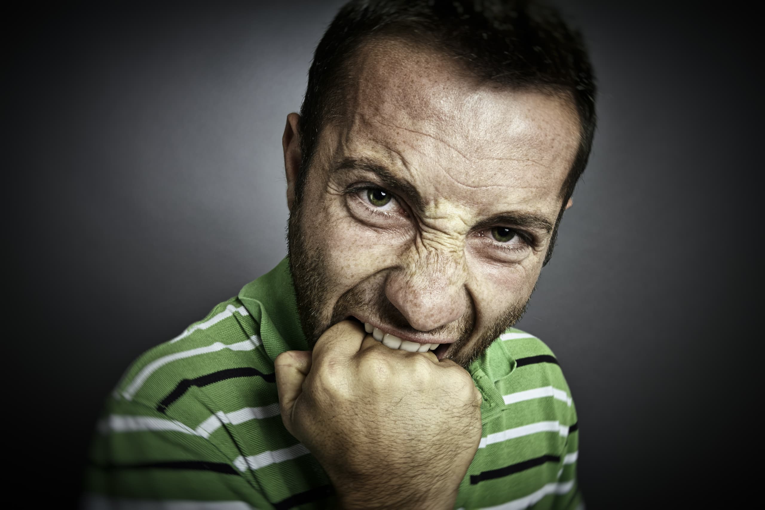 Closeup,Portrait,Of,An,Angry,Guy,Biting,His,Fist,,Looking