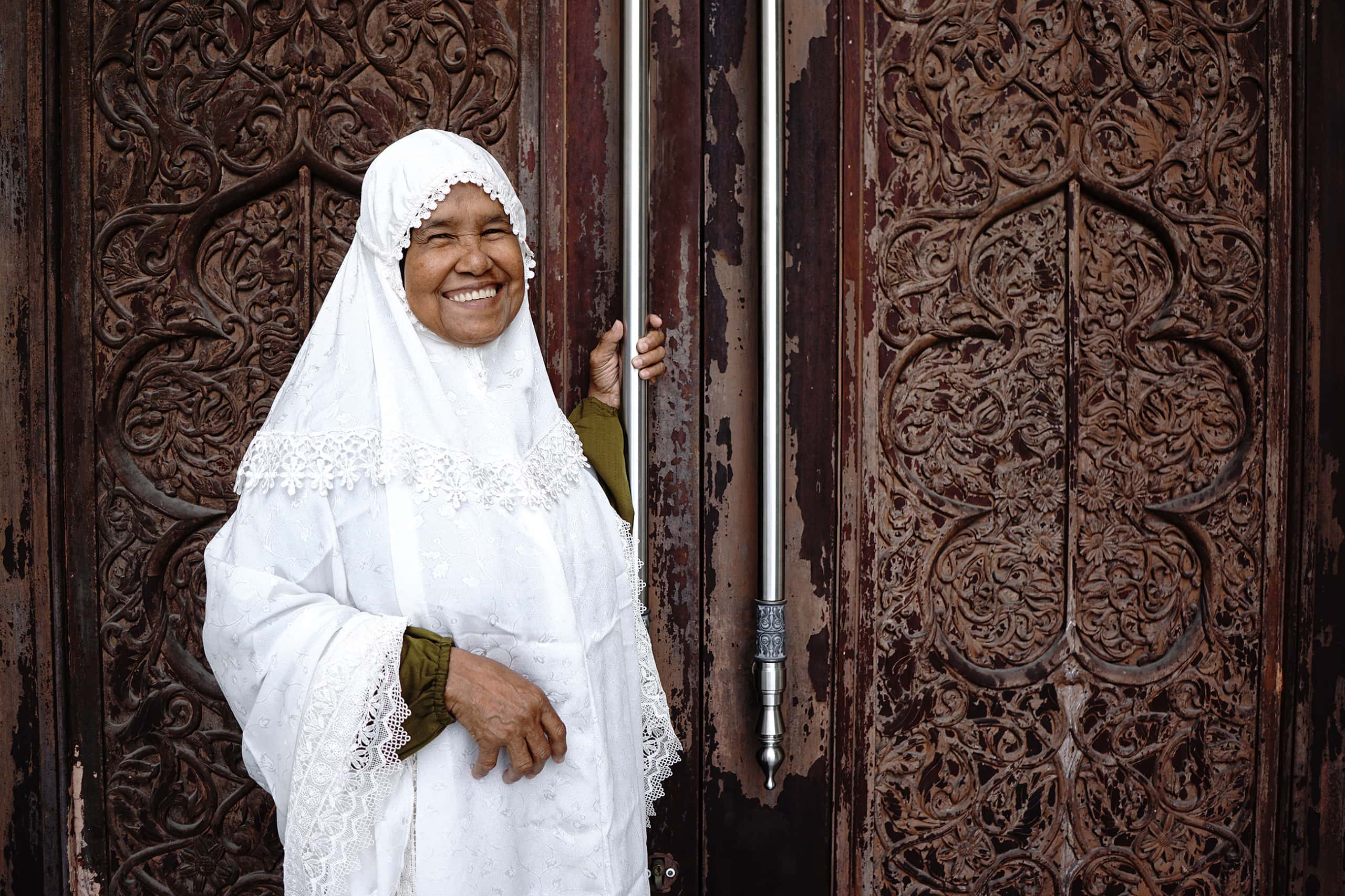 Portrait,Of,Aged,Muslim,Woman,Standing,In,Front,The,Wooden